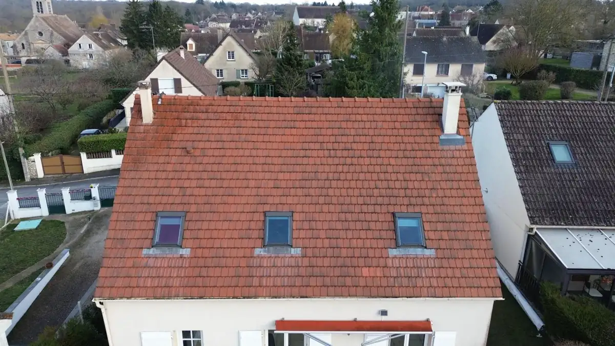 La même maison à trois fenêtres de toit après nettoyage, toiture en tuiles rouges